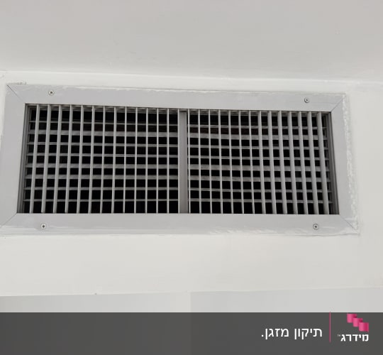 פתח אוורור של מערכת מיזוג אוויר על קיר לבן